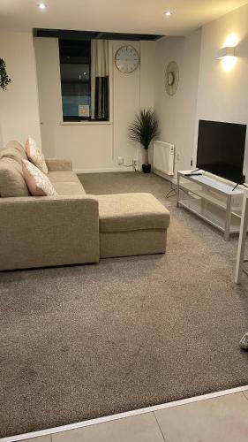 a living room with a couch and a tv at DealHouse F7- Apartments in Huddersfield