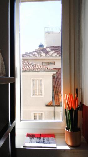 a window with a view of a building with scissors at Hotello Trieste in Trieste