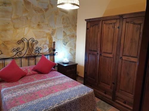 a bedroom with a bed and a wooden cabinet at La Almendra in San Bartolomé de Tirajana
