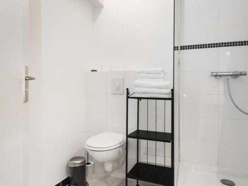 a white bathroom with a toilet and a shower at Le Gabriel in Strasbourg