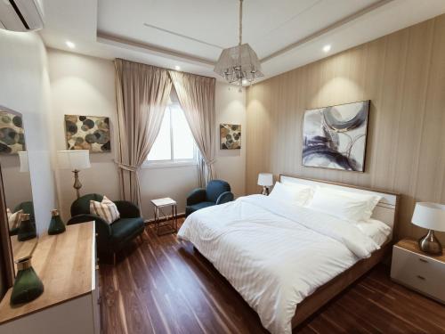 リヤドにあるF residence, Beauty & Luxuryのベッドルーム1室(ベッド1台、椅子、窓付)