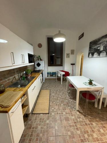 une cuisine avec des placards blancs et une table. dans l'établissement Appartamento Stazione Termini, à Rome