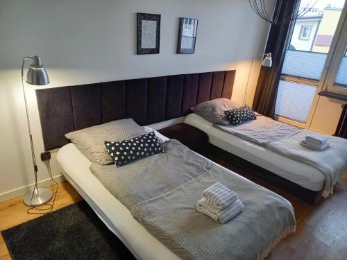 a room with two beds and a lamp in it at Brzeźno plaża in Gdańsk