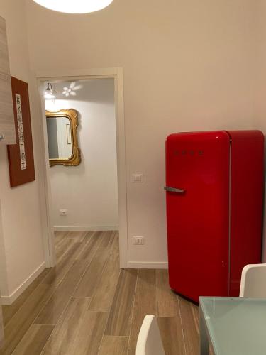a red refrigerator in a room with a mirror at UNIQUE ROOMS in Verona