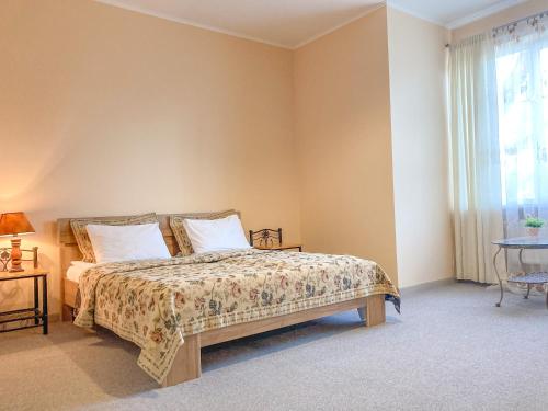スヴェトロゴルスクにあるSunny Svetlogorsk 6のベッドルーム1室(ベッド1台、テーブル、窓付)
