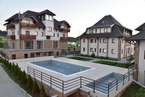 une grande maison avec une piscine devant dans l'établissement Zlatibor Hills Zeus, à Zlatibor