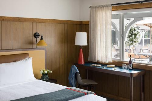 a bedroom with a bed and a desk and a window at The Virginian Lodge in Jackson