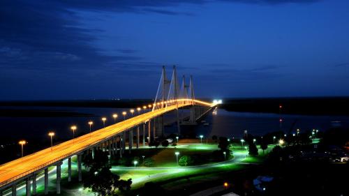 un ponte illuminato di notte con luci di Hotel Musto a Rosario