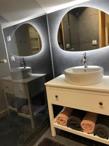 une salle de bain avec un lavabo et deux miroirs dans l'établissement Kaban' des neiges, à Saint-Gervais-les-Bains