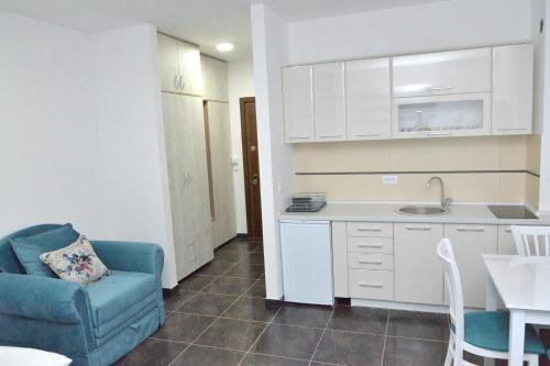 une petite cuisine avec une chaise bleue et une table dans l'établissement Zlatibor Hills Zeus, à Zlatibor