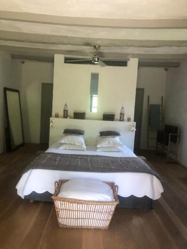 a bedroom with a large bed with a basket on it at Le Mas de Laval in Saint-Cirq-Lapopie