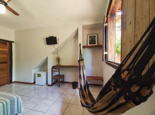 a room with a hammock in a room at Topo do Cipó Ecopousada Vegana in Serra do Cipo