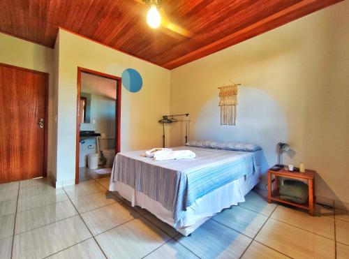 a bedroom with a bed and a table in it at Topo do Cipó Ecopousada Vegana in Serra do Cipo