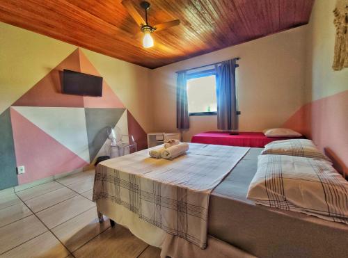 a bedroom with two beds and a ceiling fan at Topo do Cipó Ecopousada Vegana in Serra do Cipo