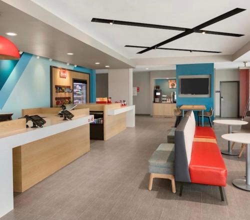 a lobby of a store with a red couch and chairs at avid hotels - Macon North, an IHG Hotel in Macon