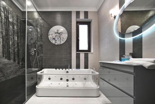 a bathroom with a bath tub and a shower at Siedmiogrodzka 7 Serviced Apartments by P&O in Warsaw