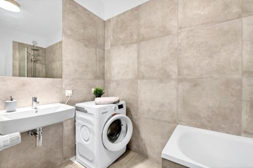 a bathroom with a washing machine and a sink at Luxury in City -2-Bright-Secure&FreeParking in Łódź