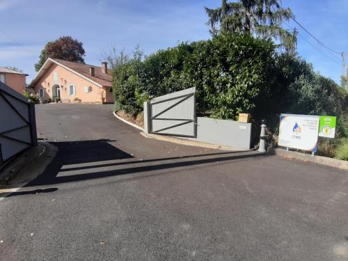 a driveway with a gate in the middle of a street at Gîte L'Ecureuil*** in MouscardÃ¨s