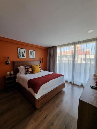 a bedroom with a large bed with orange walls at Condesa Cibel in Mexico City