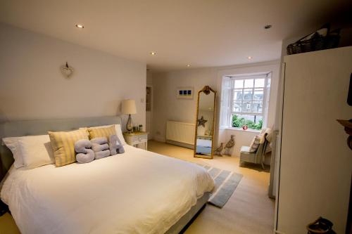 a bedroom with a large white bed with two pillows at Sea Hollies in Aberdour