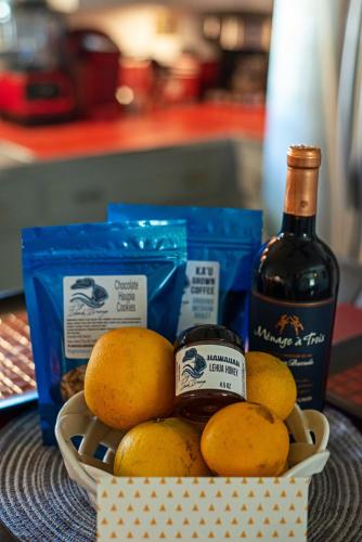a basket of oranges and a bottle of wine at Hale Leilani - Hilo 3BR cold AC in Hilo