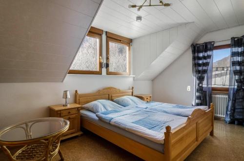 a bedroom with a bed and a chair and windows at Ferienwohnung Maria in Liggersdorf