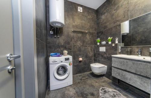 a bathroom with a washing machine and a sink at luxury apartments Smartplaza Obolon metro Minskai in Kyiv