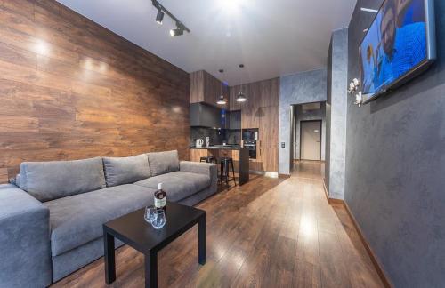 a living room with a couch and a table at luxury apartments Smartplaza Obolon metro Minskai in Kyiv