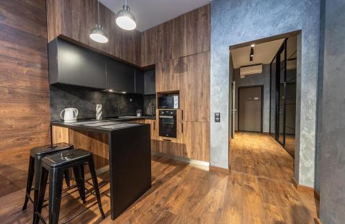 a kitchen with black countertops and wooden walls at luxury apartments Smartplaza Obolon metro Minskai in Kyiv