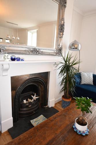 a living room with a fireplace with a mirror at No. 98 Boutique Hotel in Weymouth
