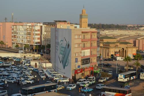 a city with cars parked in a parking lot at Hôtel Zahrat Souss -Inezgane in Inezgane