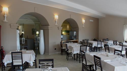 a restaurant with tables and chairs in it at Mercury Boutique Hotel in SantʼAntìoco