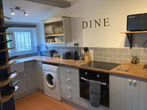 a kitchen with a washer and dryer in it at Witcroft Cottage in Pershore