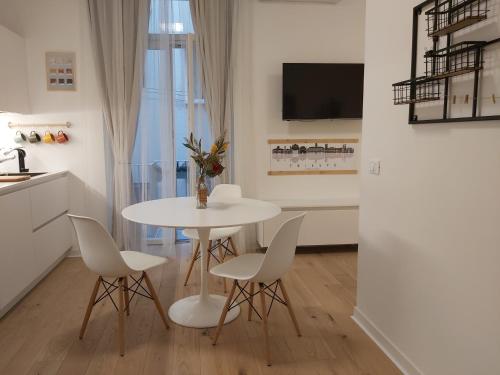 una sala da pranzo bianca con tavolo e sedie di La Casa di Adele - your Home in Trieste a Trieste