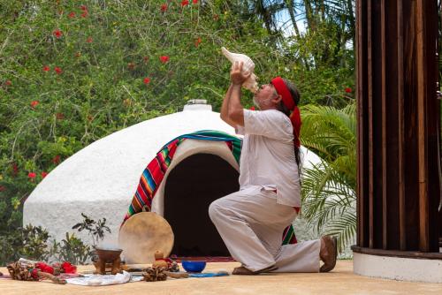 a man is dancing in front of a tent at Presidente InterContinental Cozumel Resort & Spa, an IHG Hotel in Cozumel