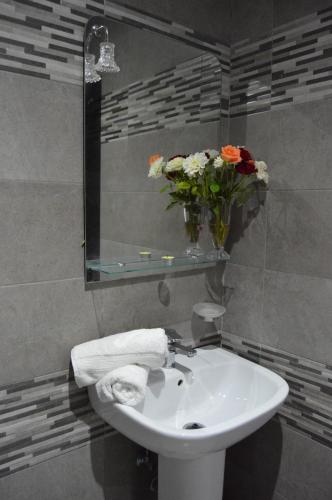 a bathroom with a sink and a vase of flowers at Hôtel Zahrat Souss -Inezgane in Inezgane