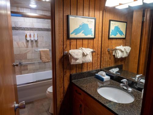 een badkamer met een wastafel, een toilet en een spiegel bij Lutsen Sea Villas in Lutsen