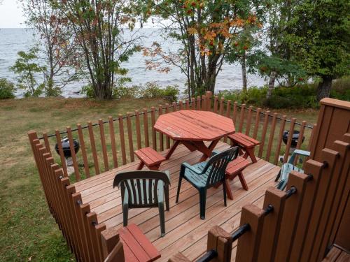 a wooden deck with a table and chairs and the water at Lutsen Sea Villas in Lutsen