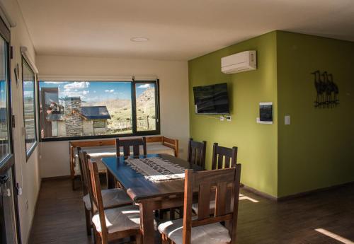 ein Esszimmer mit einem Tisch, Stühlen und einem Fenster in der Unterkunft Terrazas del Ceferino in Sierra de la Ventana