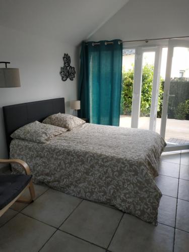 1 cama en un dormitorio con cortina azul en Studio Terrasse - Parking gratuit, en Orléans