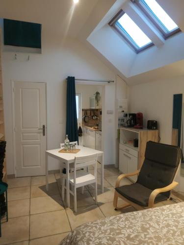 une chambre avec une table et une chaise ainsi qu'une cuisine dans l'établissement Studio Terrasse - Parking gratuit, à Orléans