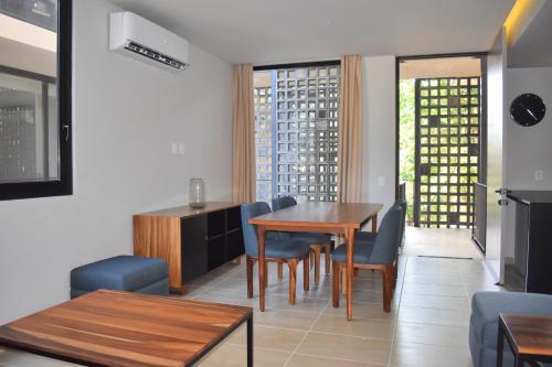 a dining room with a table and chairs at Kaab At The Park by The Spot Rentals in Playa del Carmen