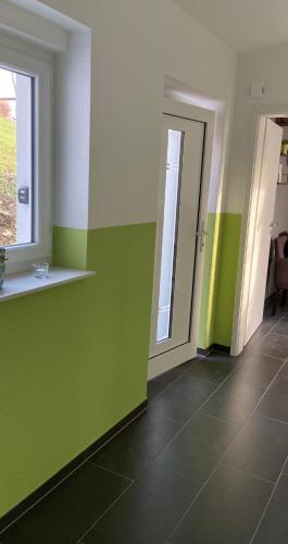 a hallway with green and white walls and a door at Modernes Ferienhaus E25, 2-6 Pers keine Monteure in Lichtenau