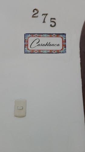 a sign on a wall with a clock on it at Casablanca 2 in Tacna