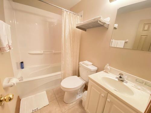Baño blanco con aseo y lavamanos en Anna's Bed & Breakfast en Cataratas del Niágara