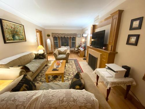 a living room with two couches and a tv at Anna's Bed & Breakfast in Niagara Falls