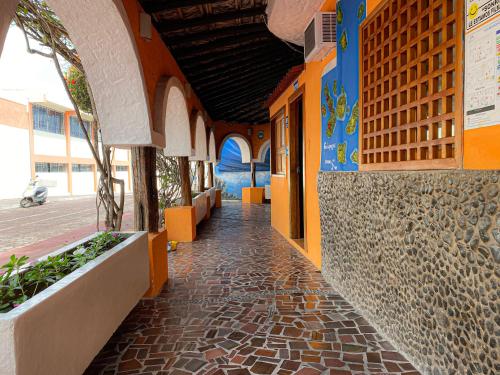 un couloir d'un bâtiment avec une passerelle en pierre dans l'établissement Hotel Crossman, à Puerto Ayora