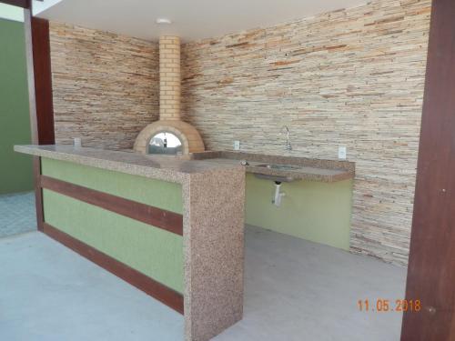 cocina con fregadero y pared de ladrillo en Flat Golden lake, en Arraial do Cabo