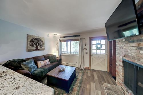 a living room with a couch and a fireplace at Hi Country Haus 14-5 in Winter Park