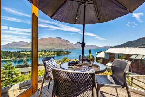 a patio with a table and chairs and a view of the water at Sun-filled on Wakatipu in Queenstown